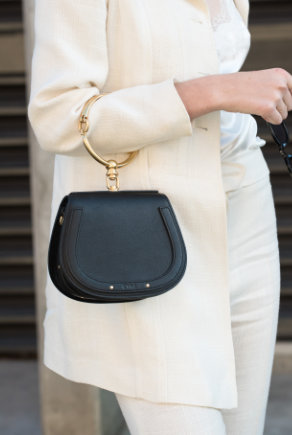femme en blanc portant ptit sac noir