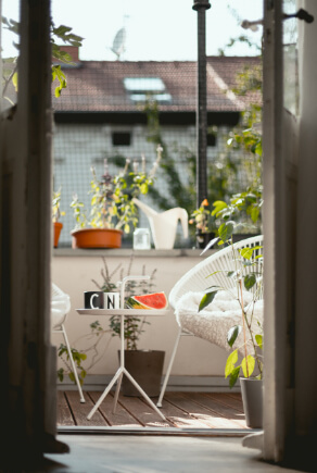 Table basse et chaises blanches sur balcon au soleil