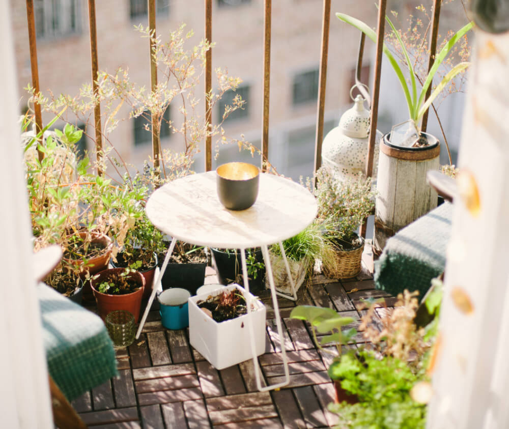 Plantes, table basse et bougie sur un balcon en bois