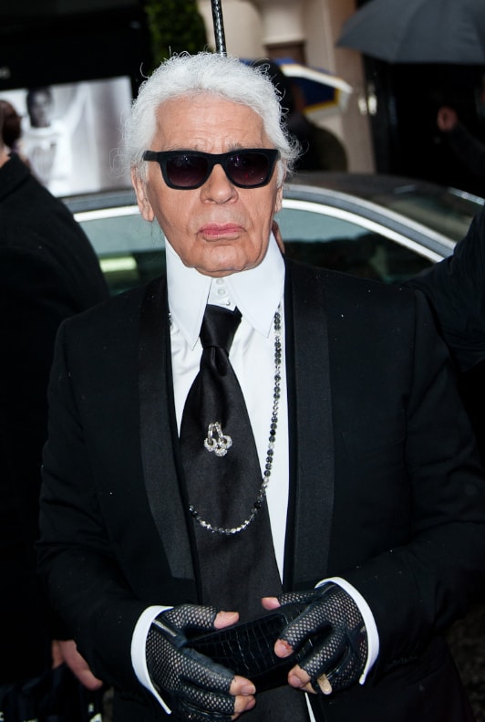 Karl lagarfeld en costume noir avec des lunettes de soleil