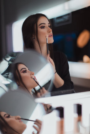 femme qui se maquille devant le miroir