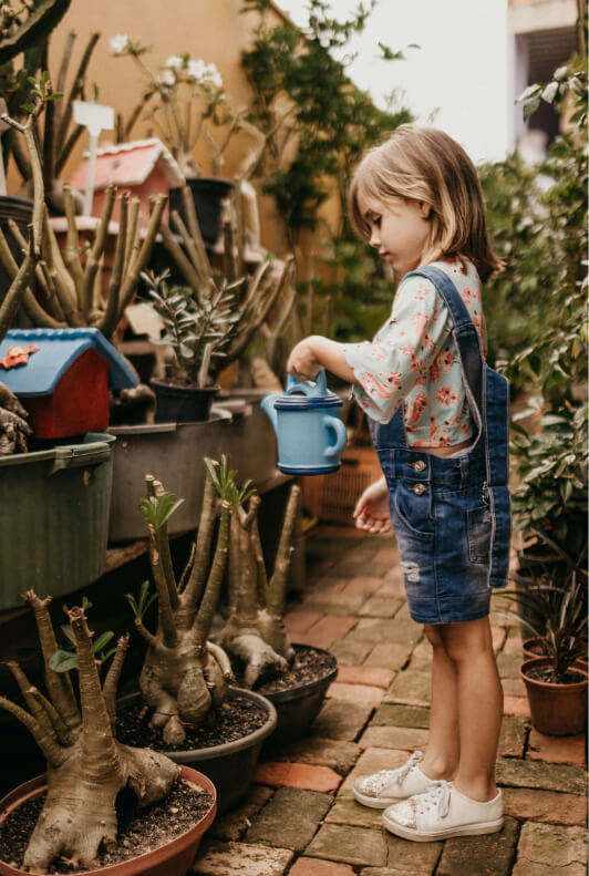 petite fille arrosant des plantes